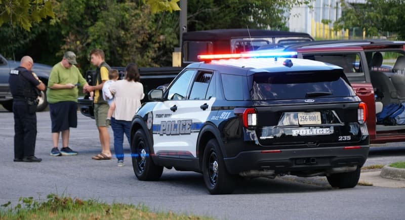 Front Royal, Virginia, U.S.A - Sep 2, 2025 - A police officer speaks with civilians next to a marked police vehicle