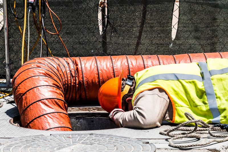 Worker Looking Down Manhole