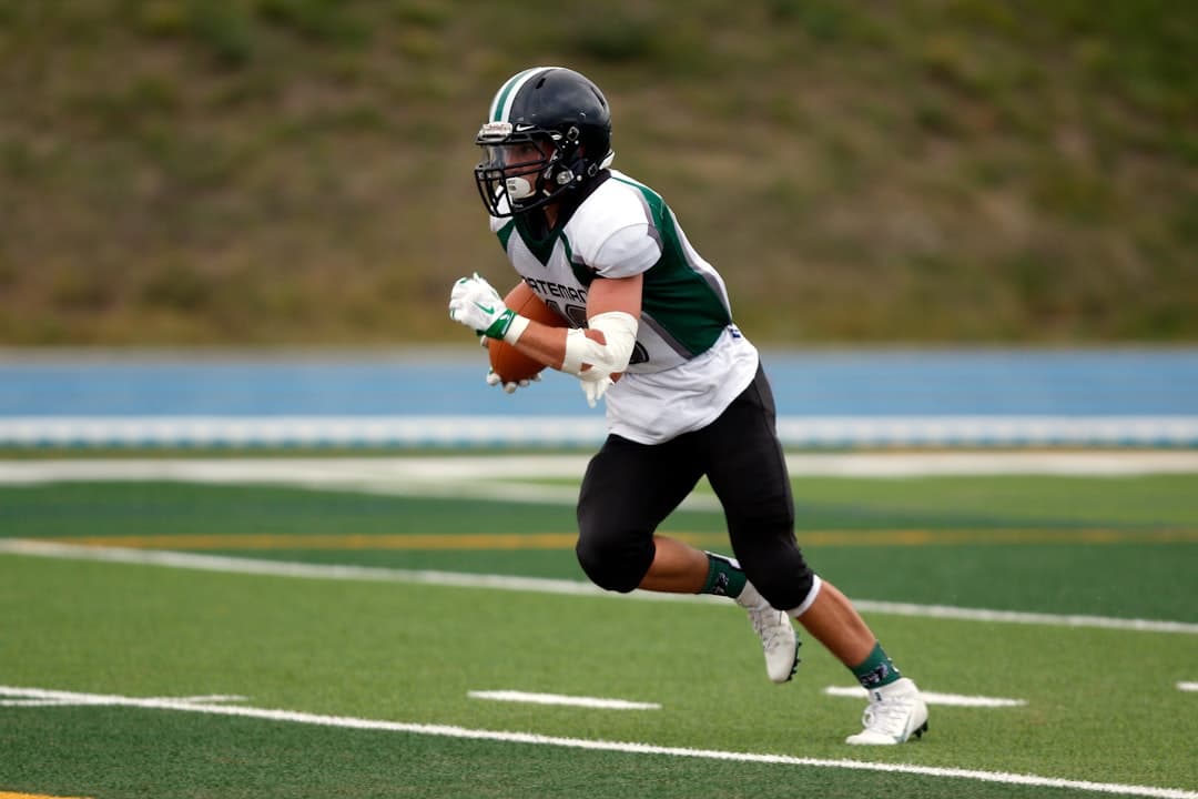 High school football player returns a kick in a football game.