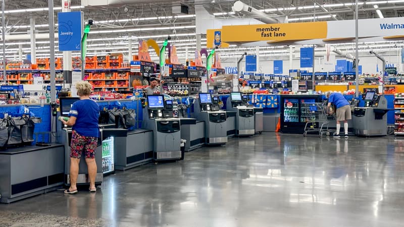 Walmart self-checkout area with customers and visible member signage