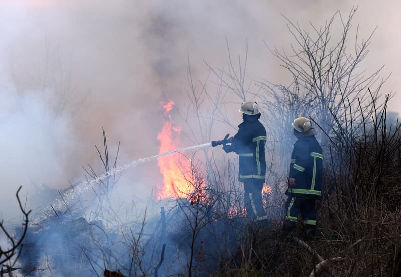 Firefighters spray water to wildfire. firefighter extinguishes a